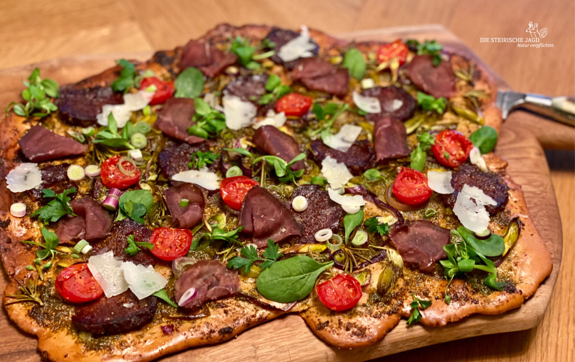 Flammkuchen mit Wildfleisch darauf.