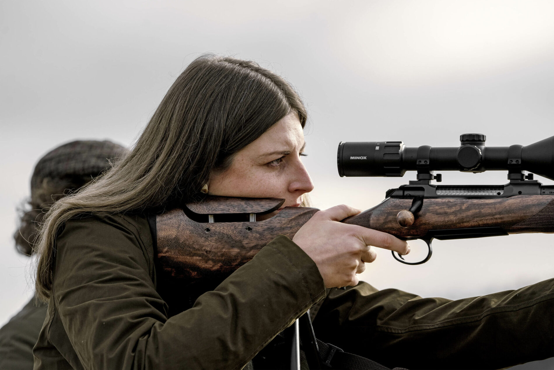 Eine Jägerin mit einer Büchse im Anschlag.