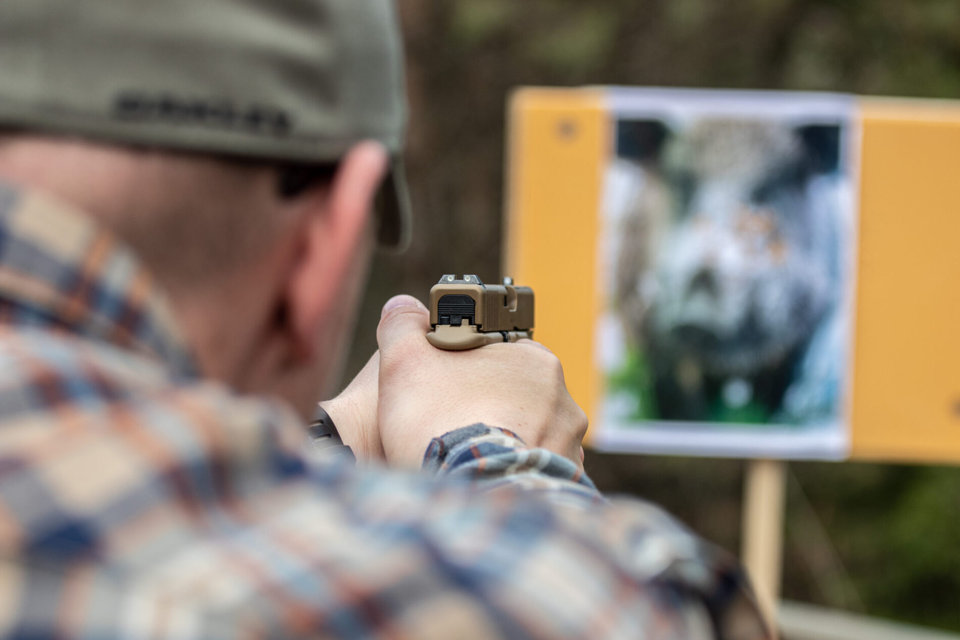 Jagdliches Übungsschießen mit Faustfeuerwaffen. Ein Schütze zielt mit einer Pistole auf eine Keilerzielscheibe.
